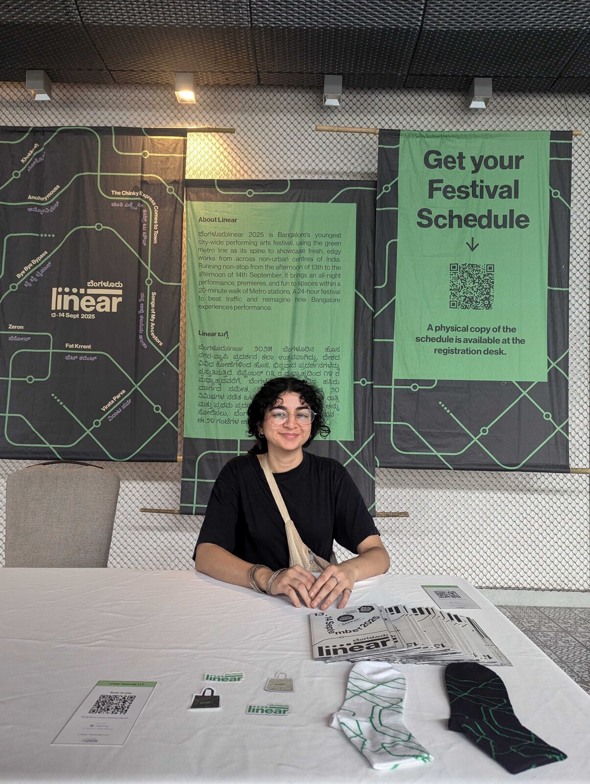 The Linear Bengaluru registration desk, with About Linear and Get your Festival Schedule banners behind and merch on the table